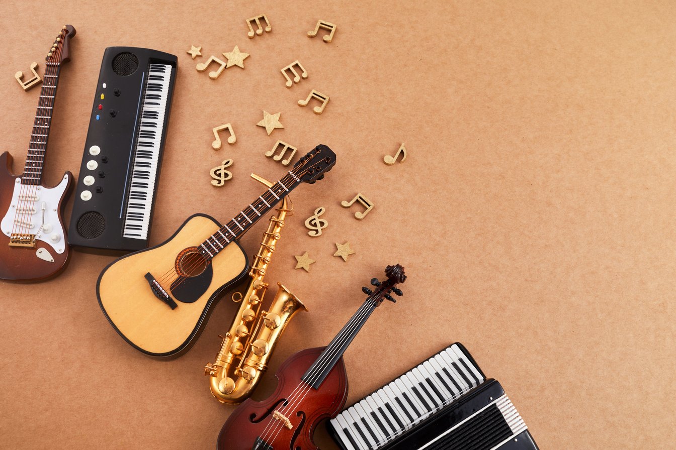 Happy world music day. Musical instruments on brown background.